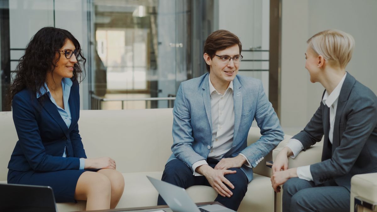 Three professionals discussing work in a modern office