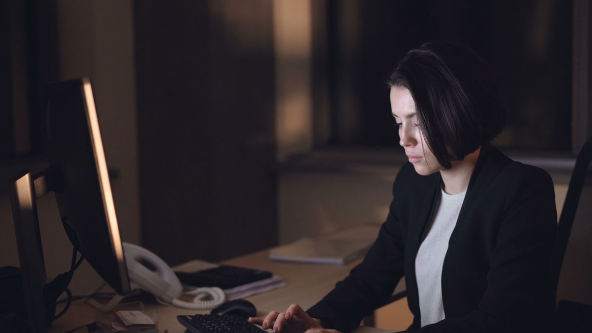 Professional woman working at a computer in a dim office